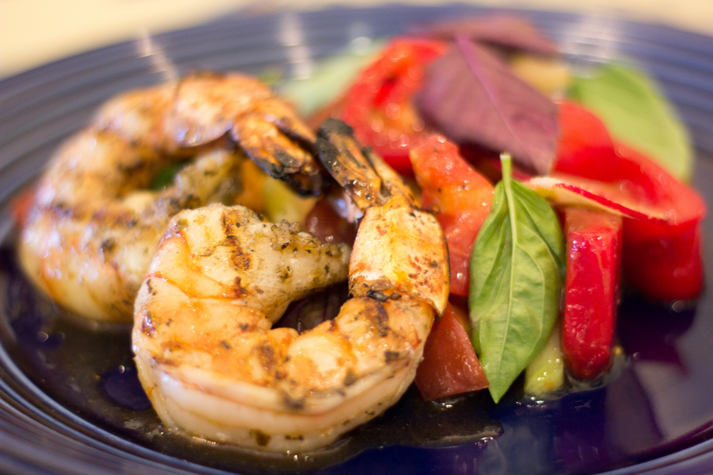 A plate of grilled shrimp with fresh tomatoes and greens at Chaumette Winery's Grapevine Grill