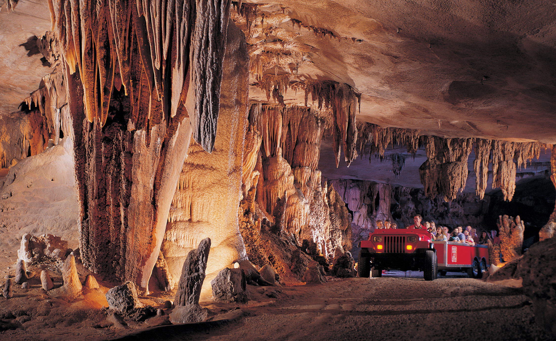 Jeep-drawn tram near cave coral and columns