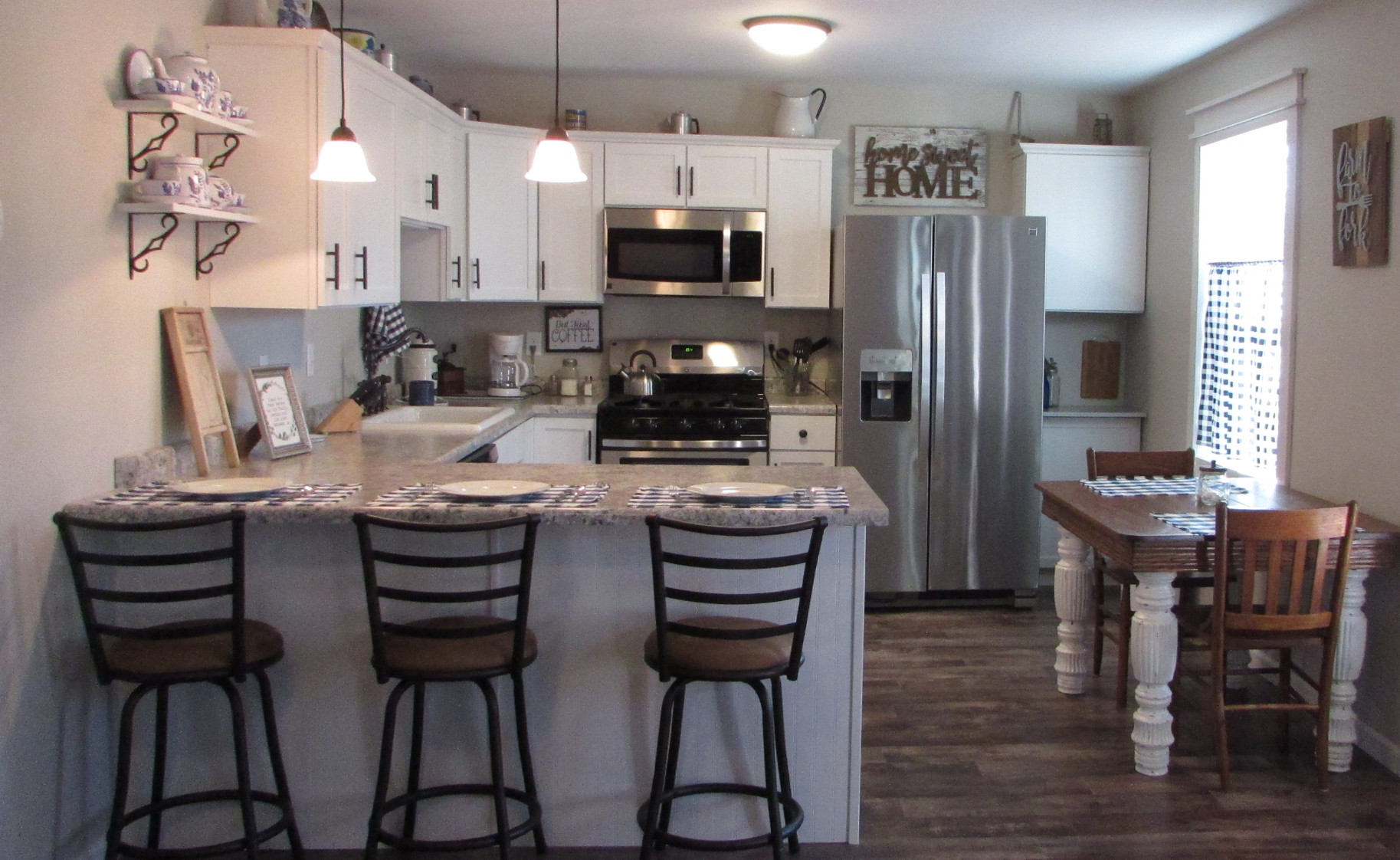 Kitchen with bar will seat . has plenty of dishes and cookware