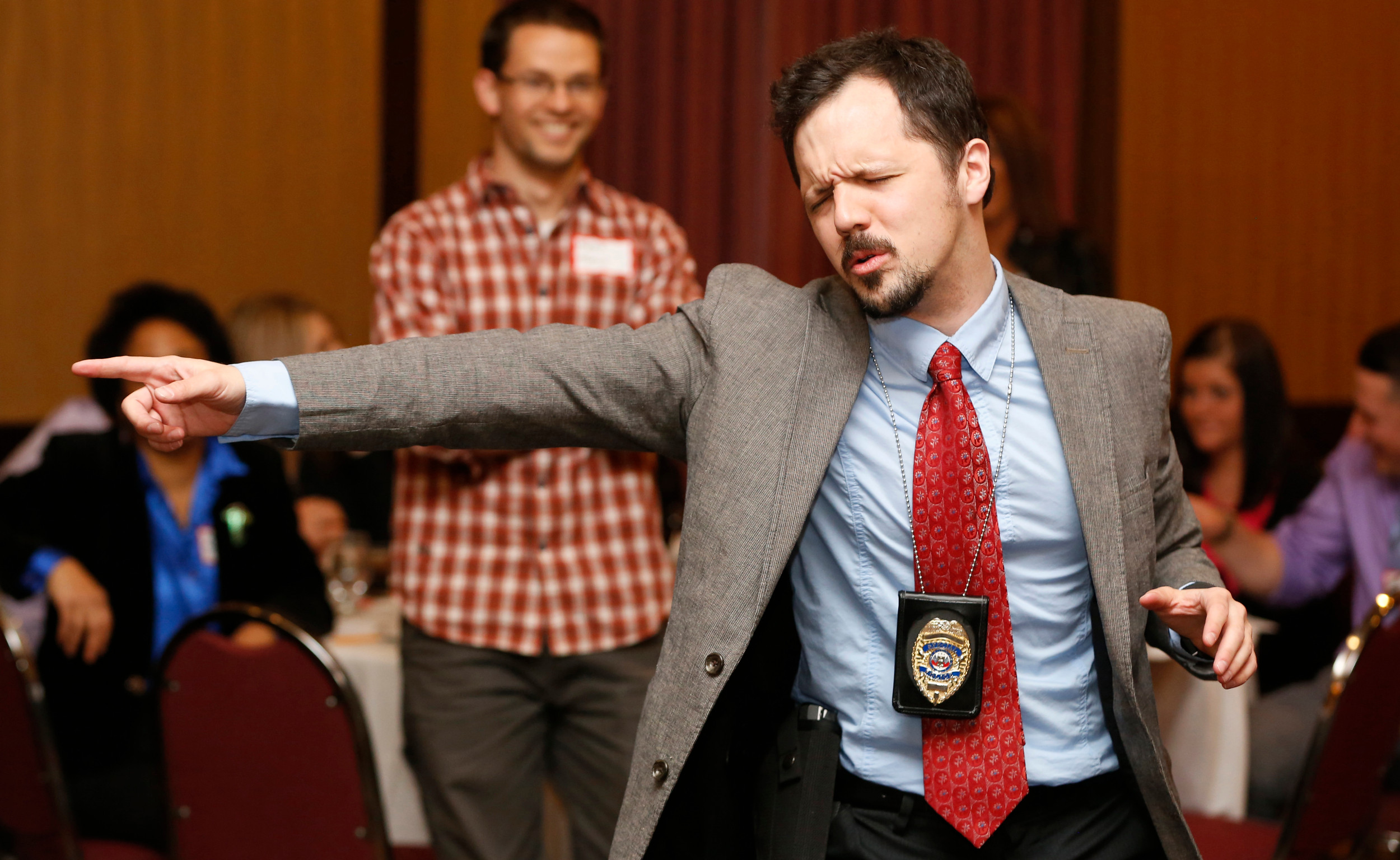 Nick Rowley, playing the role of detective Richard Less, gets excited over clues March 28, 2014 during The Dinner Detective event at the Embassy Suites in Des Moines.