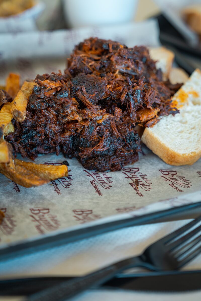 Shredded burnt ends from Arthur Bryant's piled high on a tray, showcasing tender, smoky pieces of BBQ with a caramelized bark and rich, glistening texture on a tray.