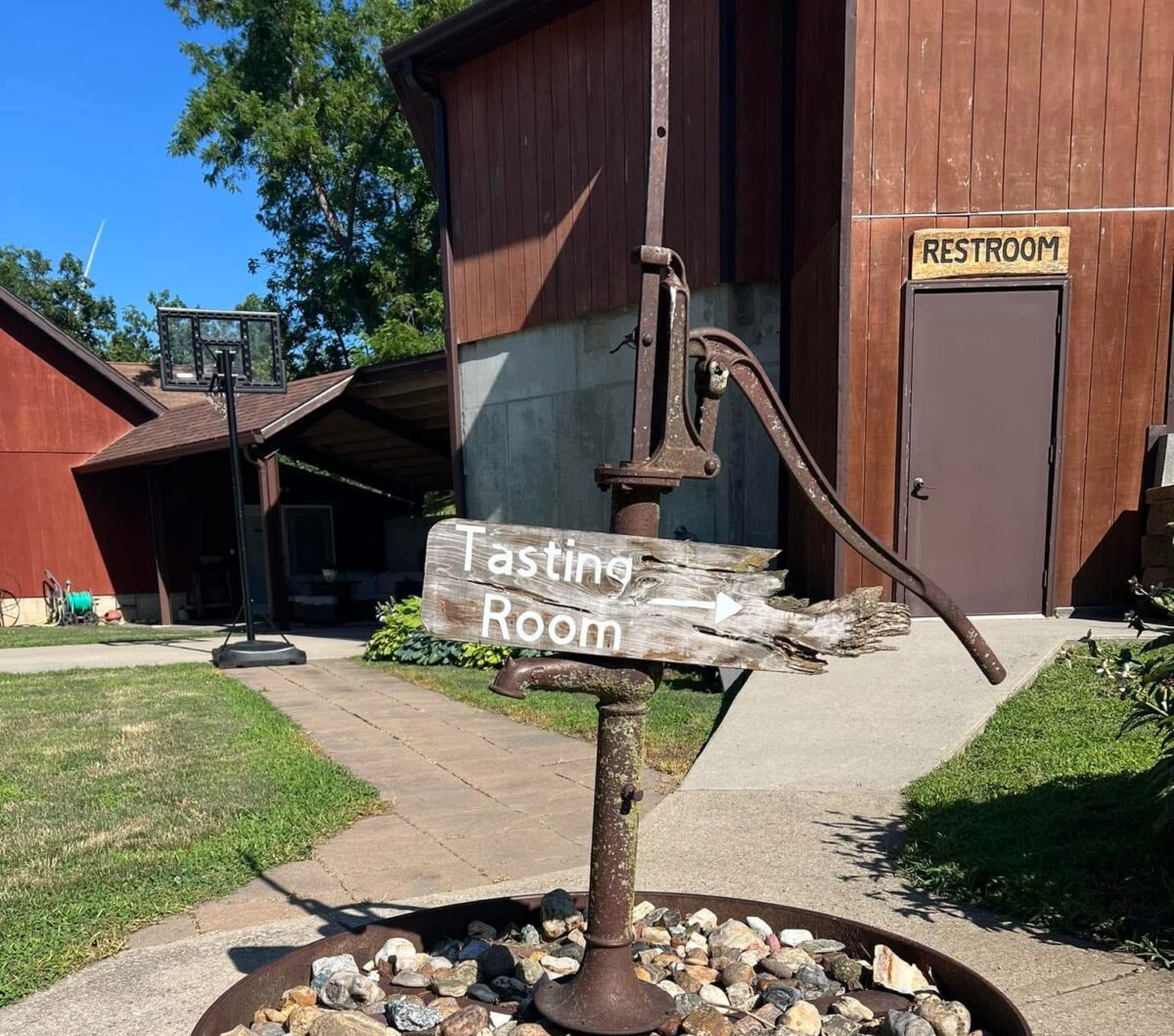 A water spigot with a sign that reads "tasting room"