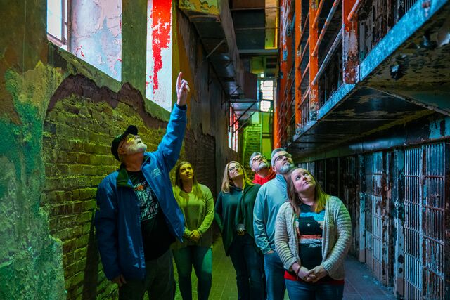 A tour guide lead a group of people through the historic Missouri State Penitentiary.