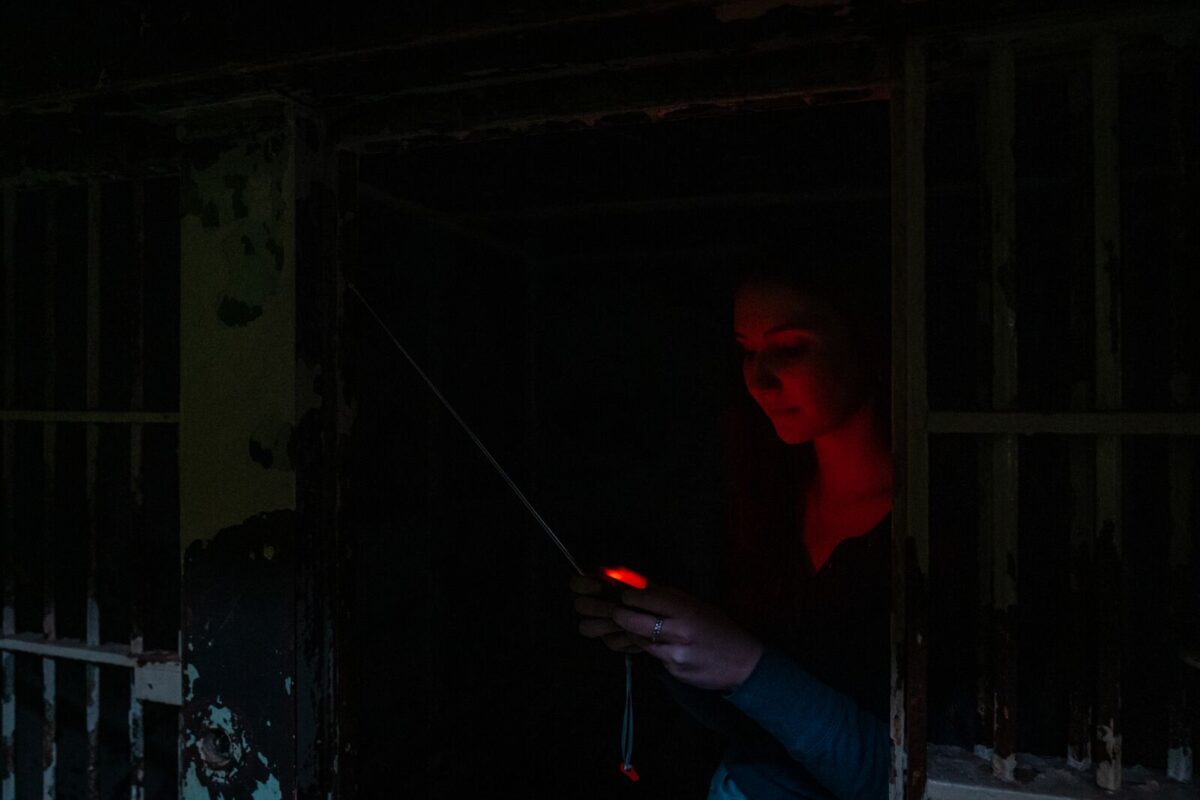 A woman uses ghost-hunting equipment for a paranormal investigation at the historic Missouri State Penitentiary.