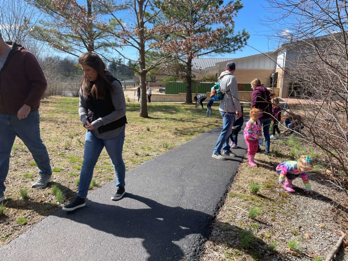 Adults and children mingle along a path.