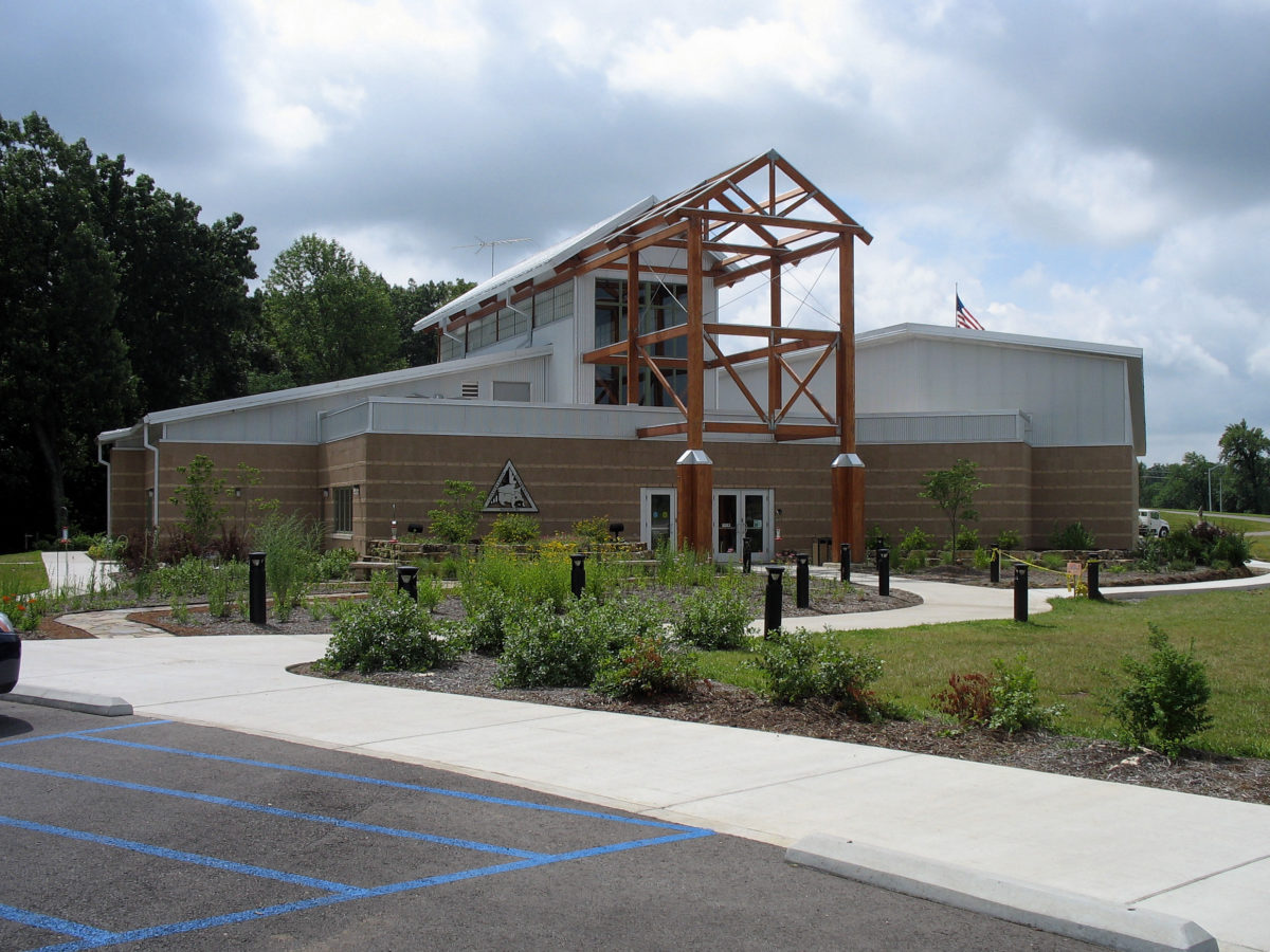 A brick building near grass and a parking lot.
