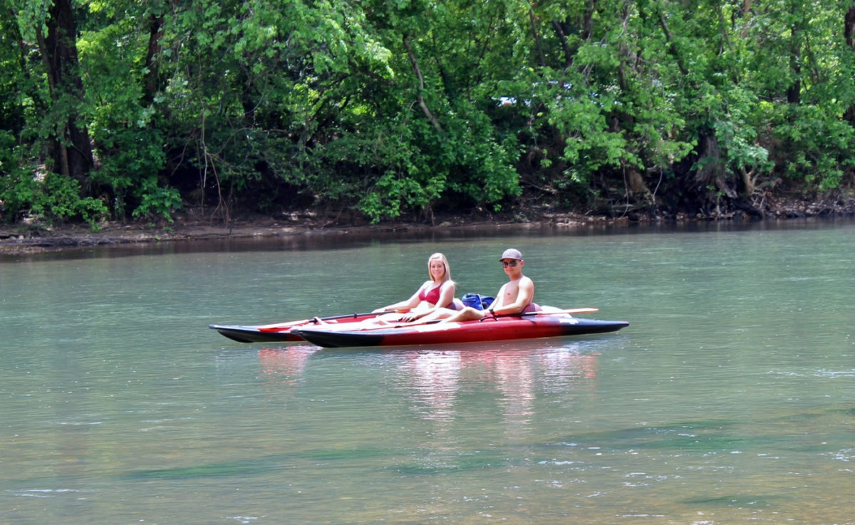 People canoeing along a river.