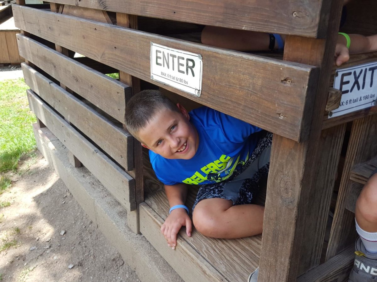 A child poses in a wooden crate.
