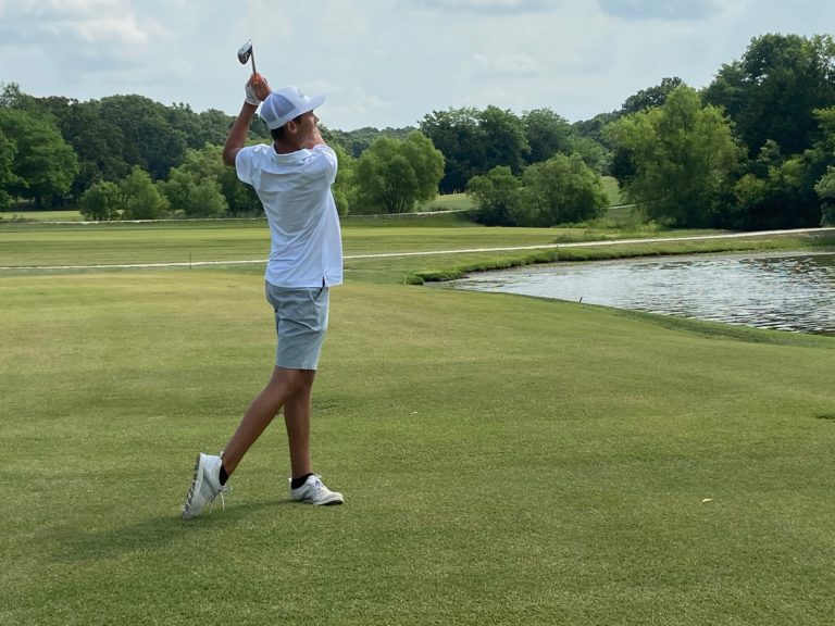 A golfer mid-swing on the greens.