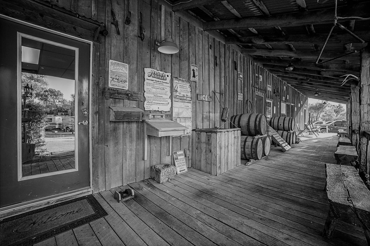 A black and white photo of a front porch.