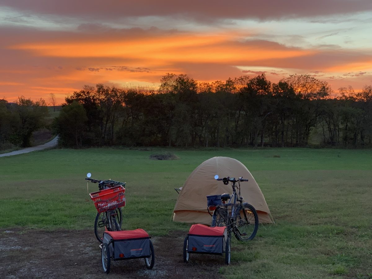 Tent and bicycles outdoors during a sunset.