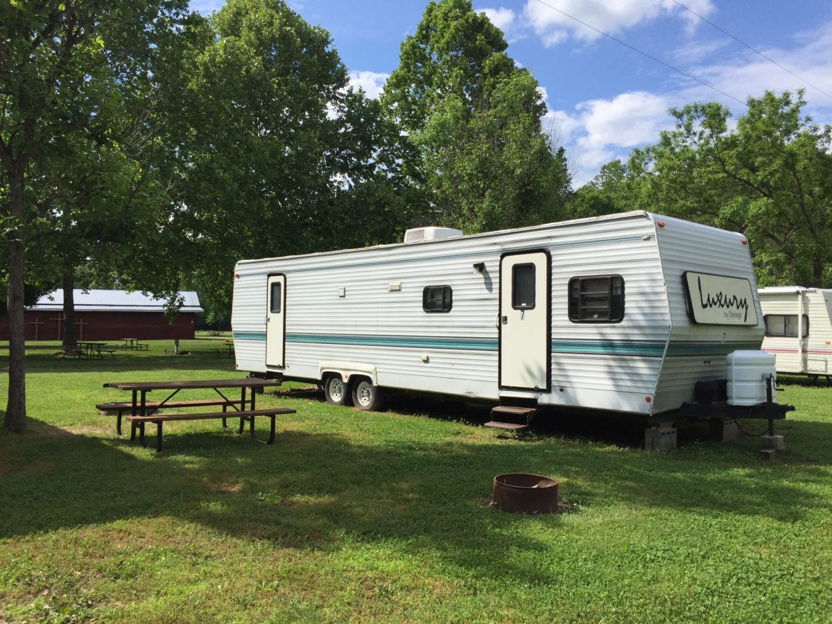 A camper close to a picnic table area.