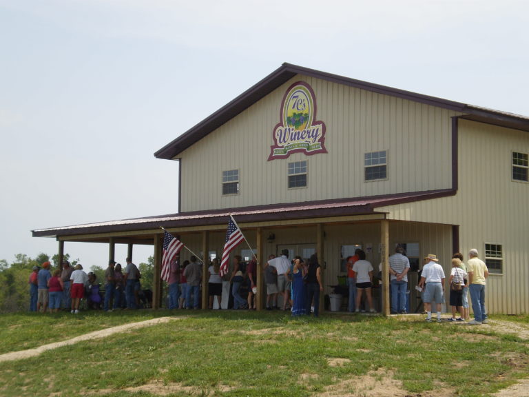 A crowd gathered outside of a winery.