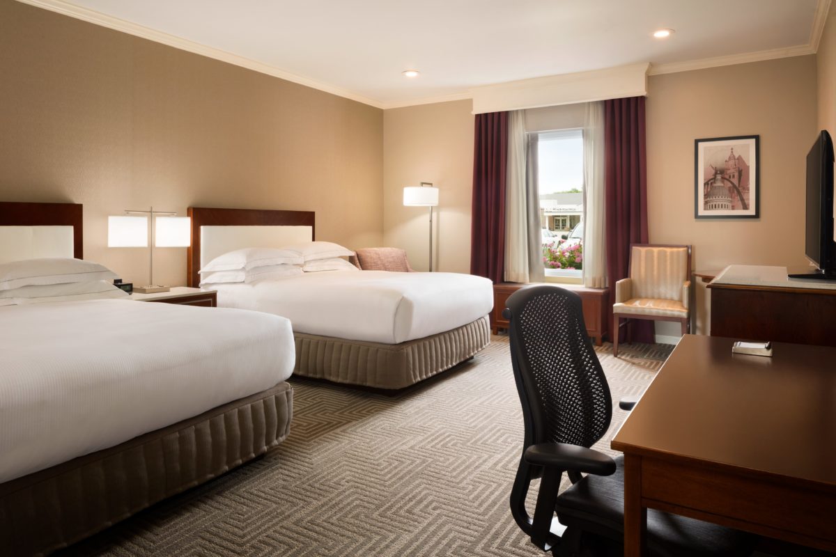 The interior of a furnished and well-lit hotel room.