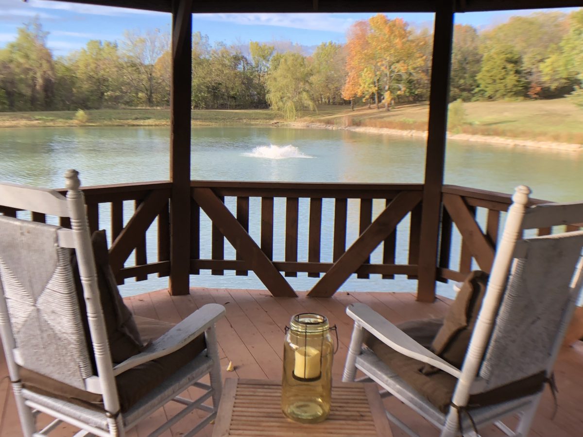 Lounging chairs on a water-side deck outside.