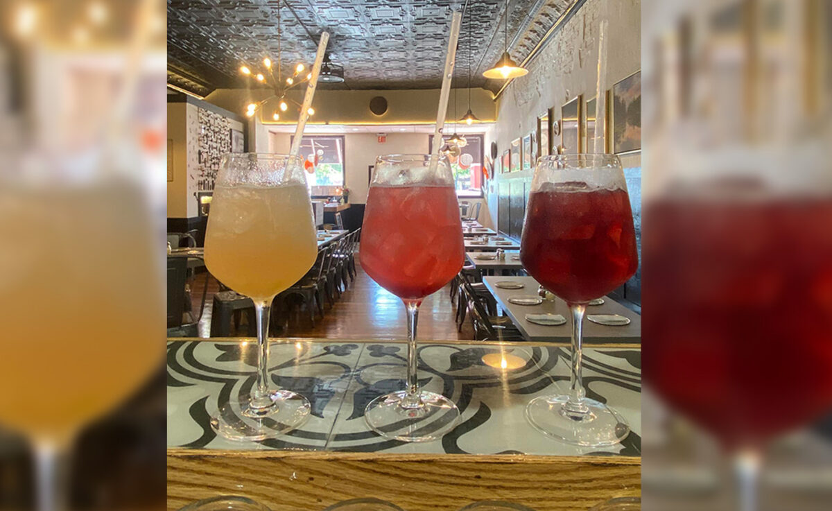 Three iced drinks in wine glasses.