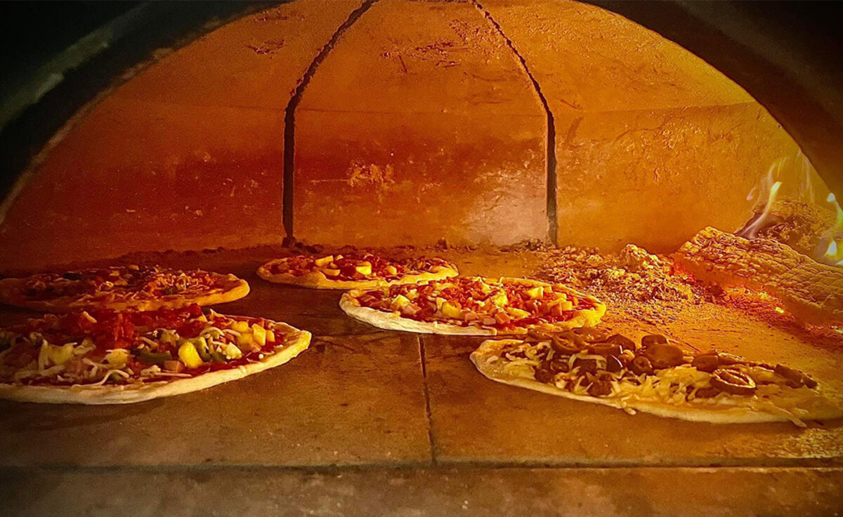 Several pizzas baking in an oven.