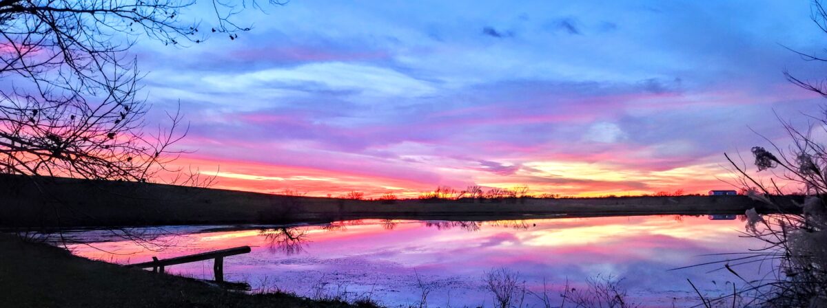 A pond and sky at sunset.