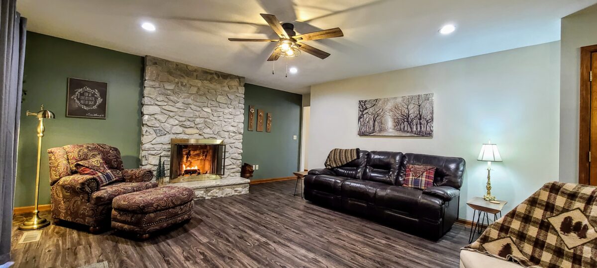 A furnished living room with wood and stone accents.