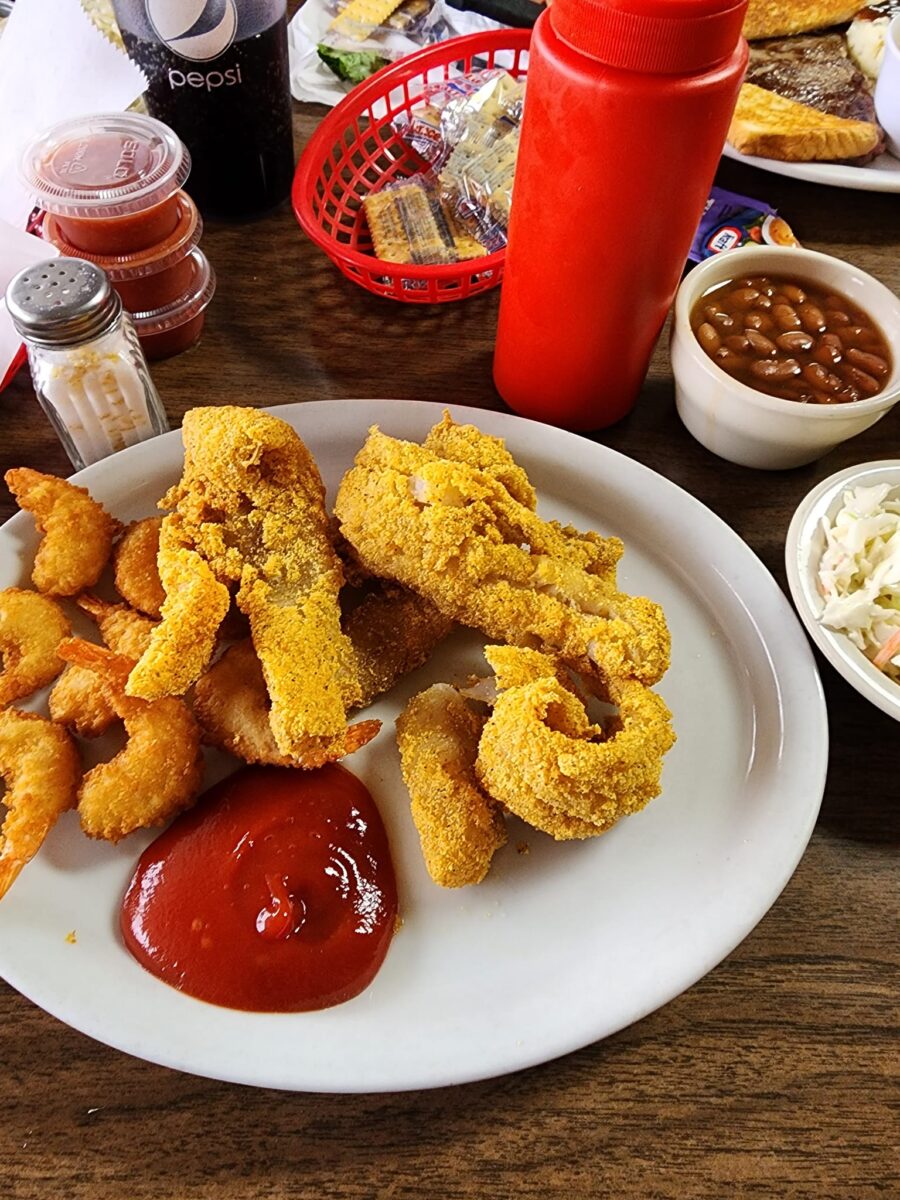 A plate of catfish with ketchup.