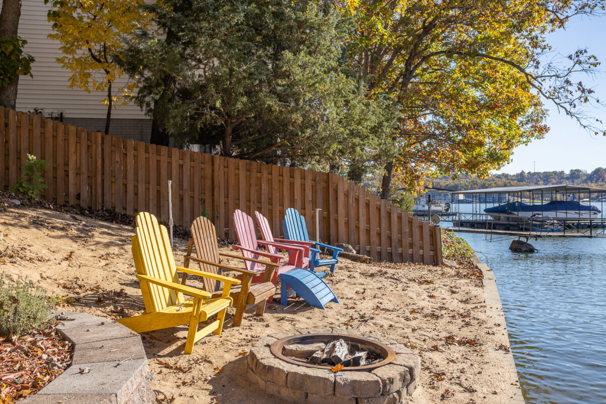 Colorful lakeside chairs outside of a large vacation house.