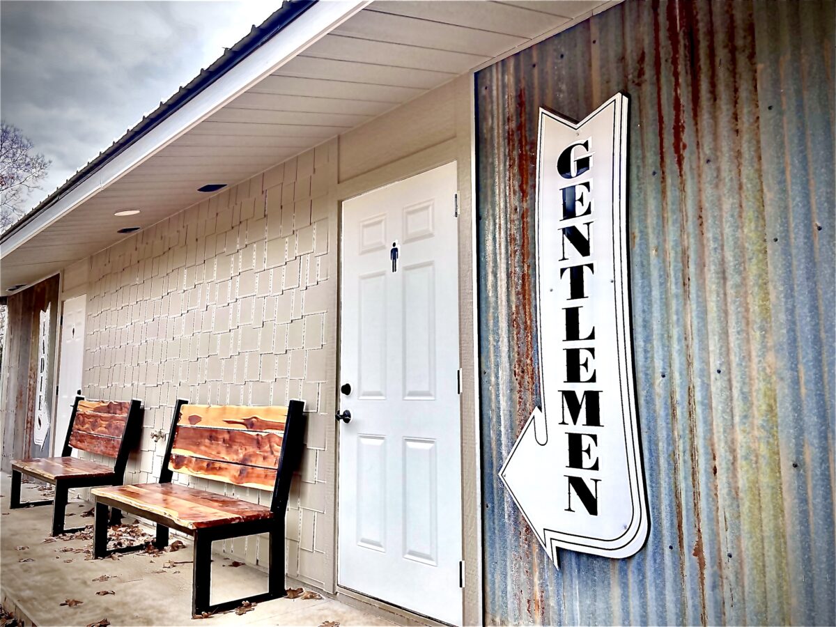 A "gentlemen" sign outside of a restroom.