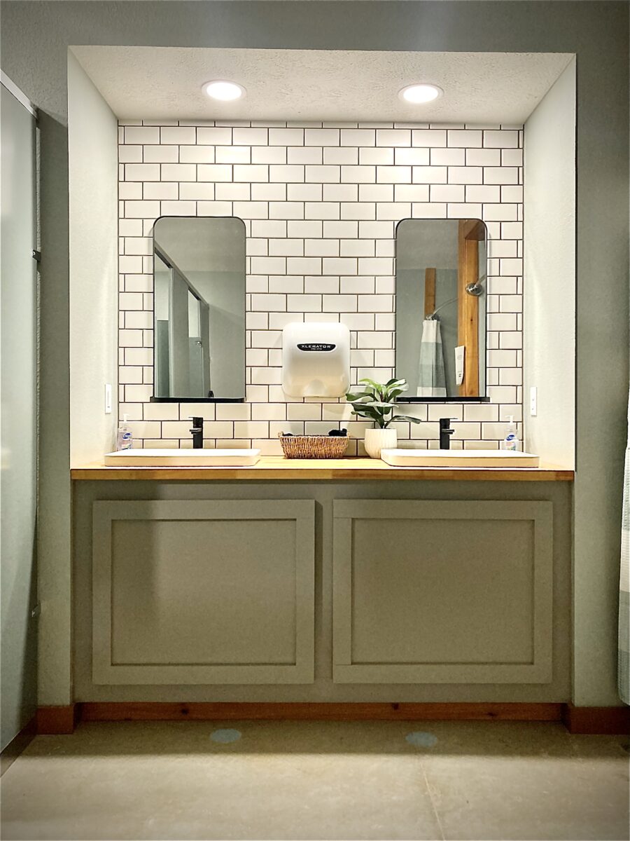 The interior of a restroom with mirrors and tiled walls.