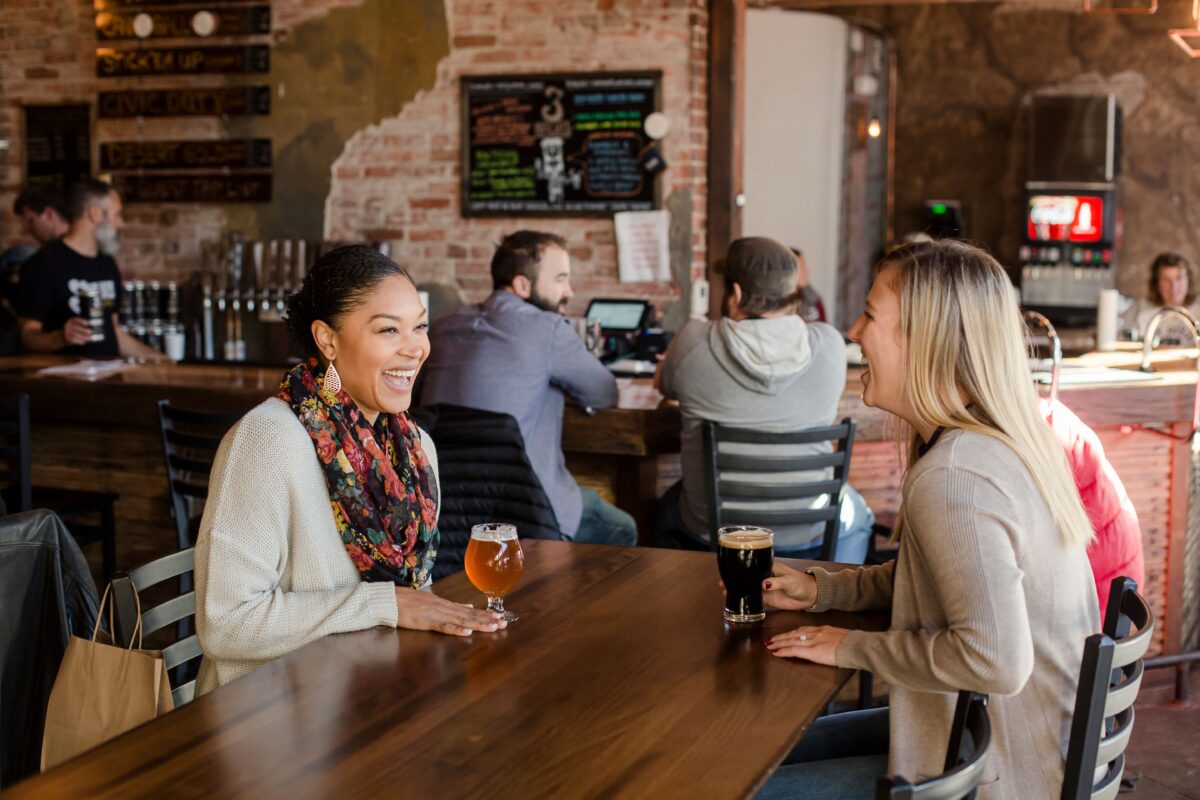 People visit at a bar.