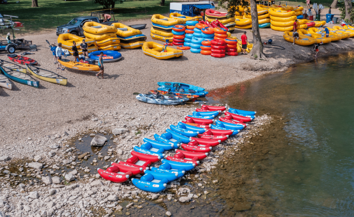 Several multicolored vessels arranged together in shallow water and on the shore.