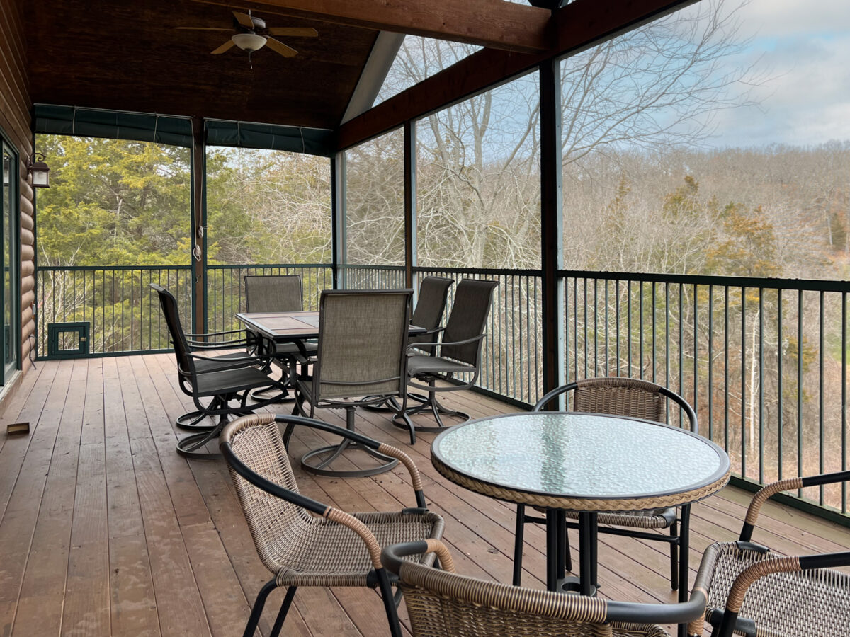 The furnished patio of a large vacation home with a view.