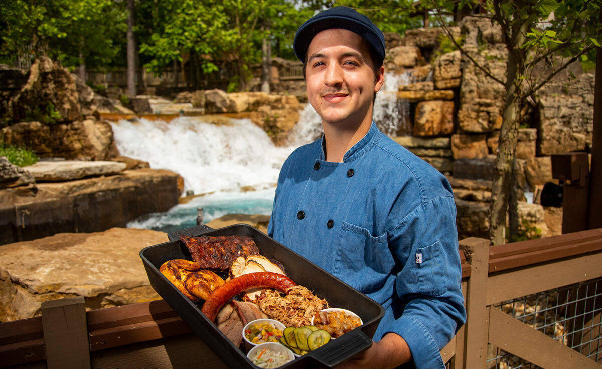 Man holding a platter of Silver Dollar City BBQ