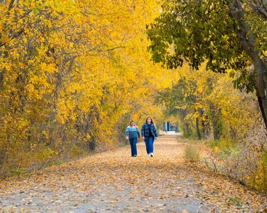 Two women hiking on the Katy Trail in the fall.
