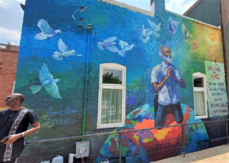 A colorful wall mural depicting a man between two windows.
