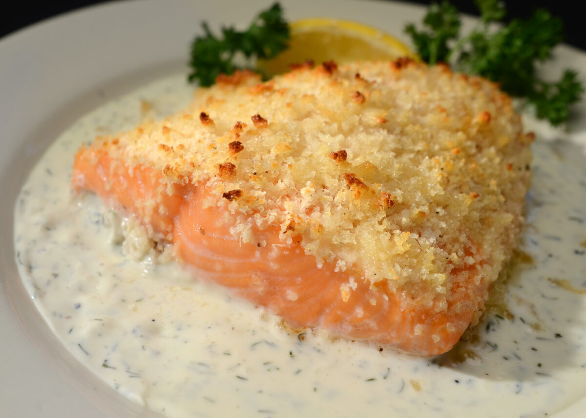 Horseradish encrusted salmon, plated on a table.