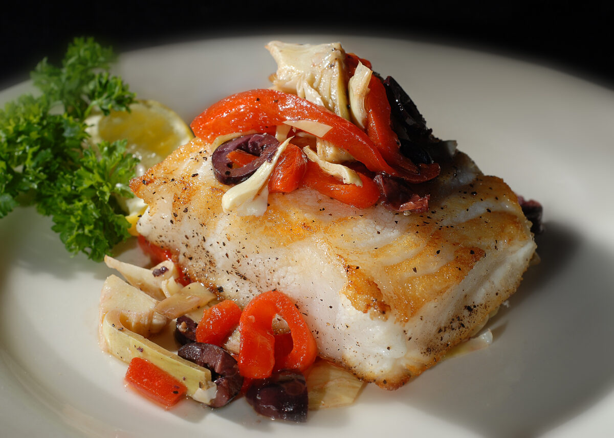 Sea bass with garnish, plated on a table.