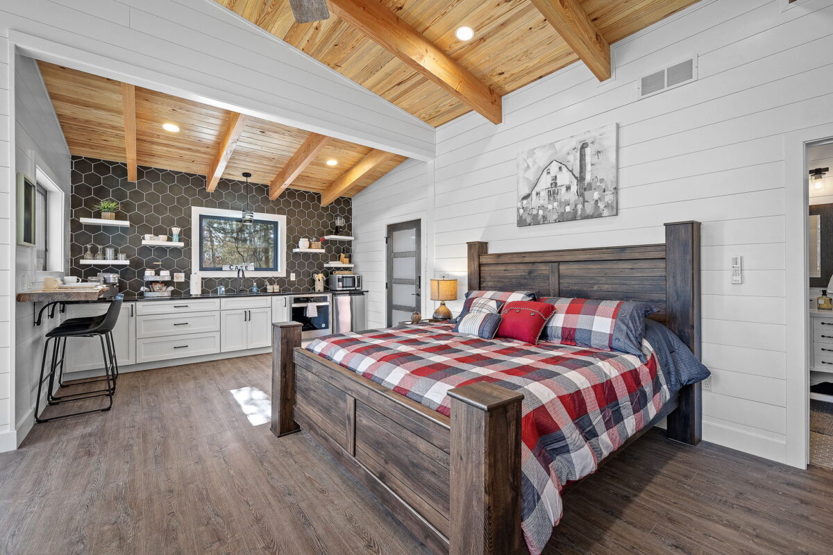 The interior of a treehouse bedroom with a large bed and storage space.