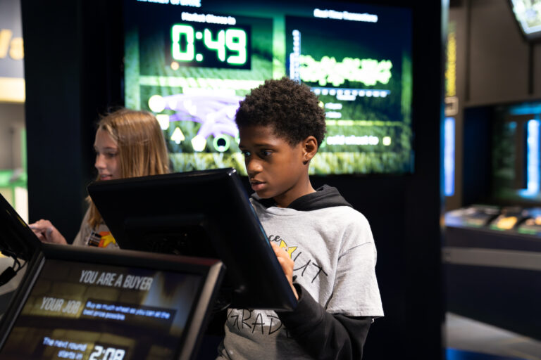 Students interact with exhibits and displays in a museum.