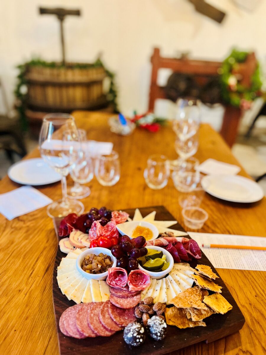 A charcuterie board and wine glasses on a table.