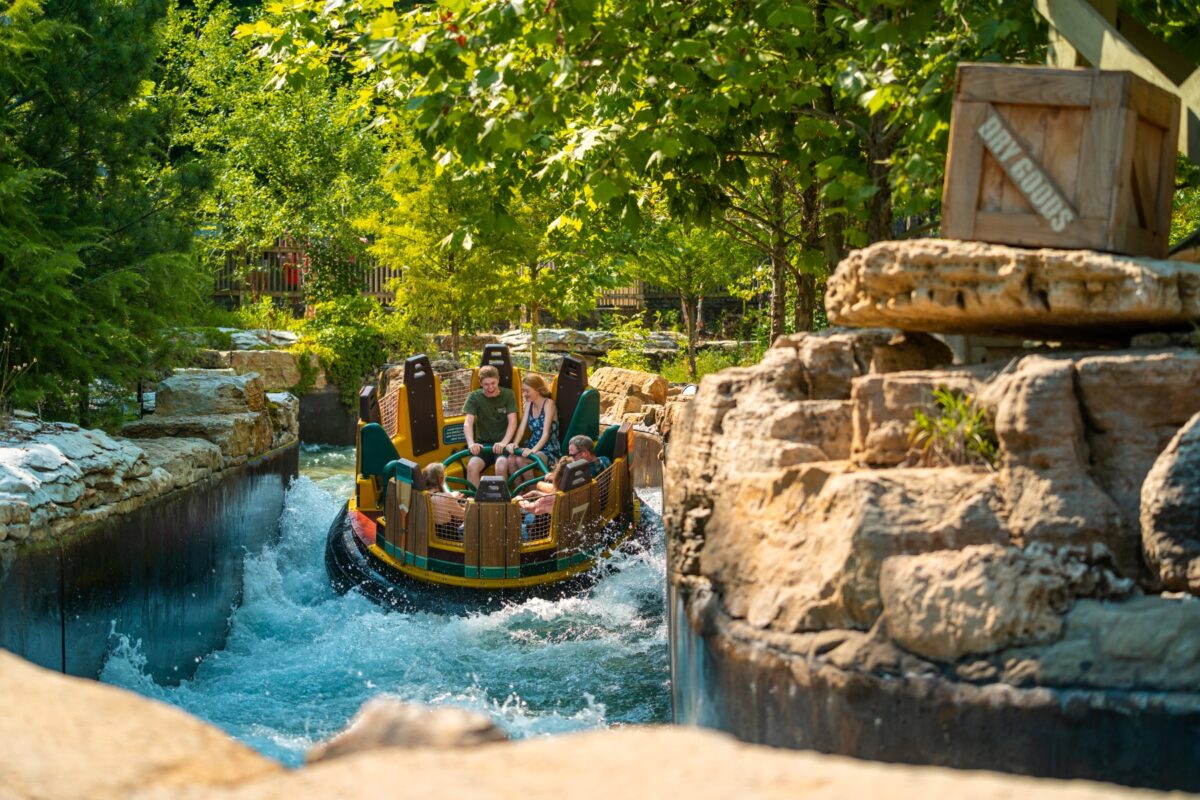 People in a raft on a water ride at a theme park.