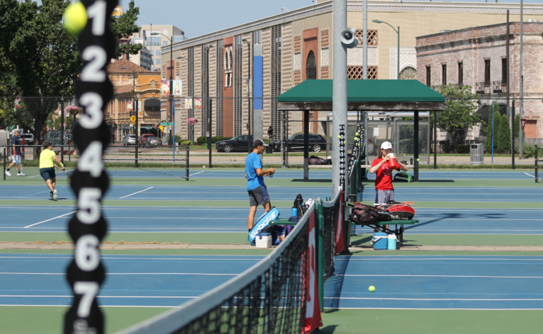 A photo of two players taking a break on the Plaza Tennis Center courts.