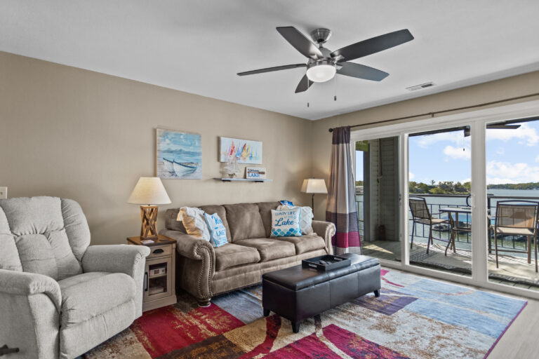 The living room of a condo with furniture and a doorway to the patio.