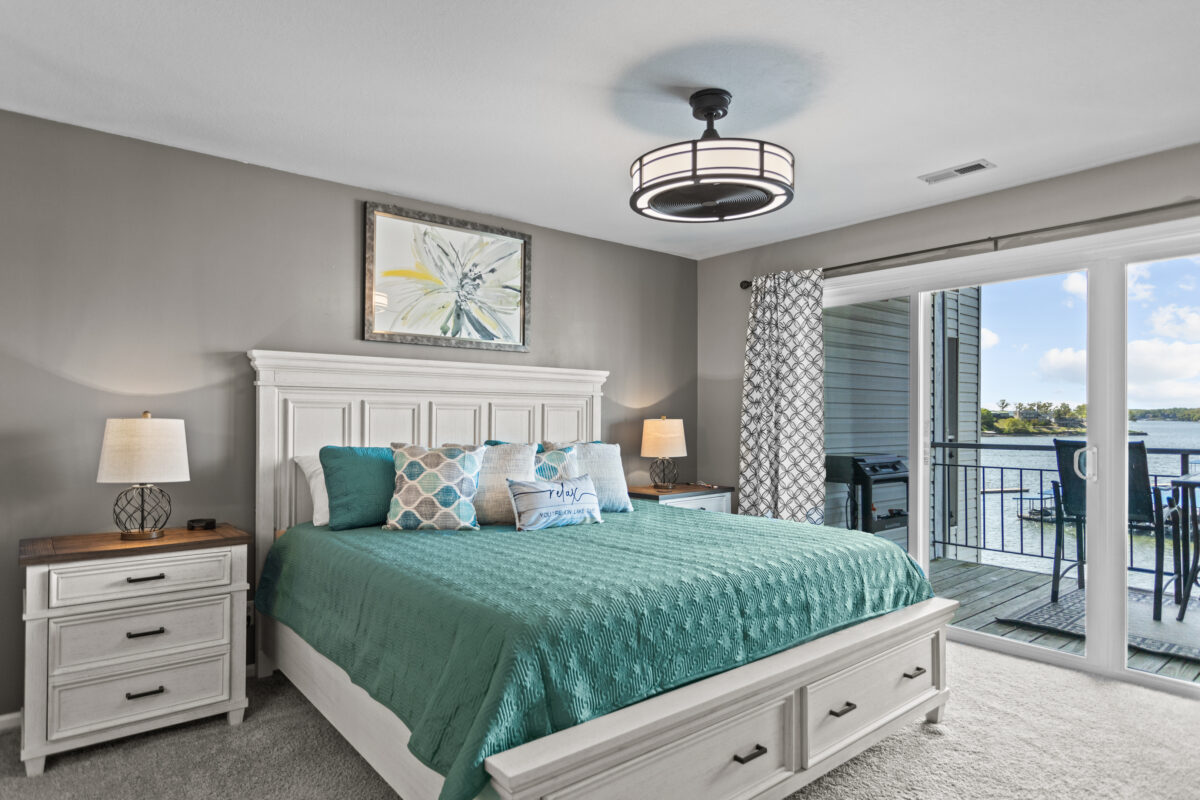 A bed with teal furnishings in the bedroom of a condo.