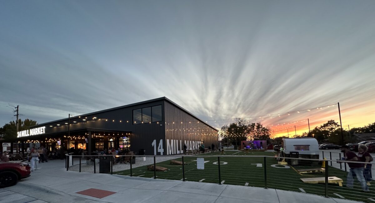 The exterior of a large food hall against a brilliant sky.