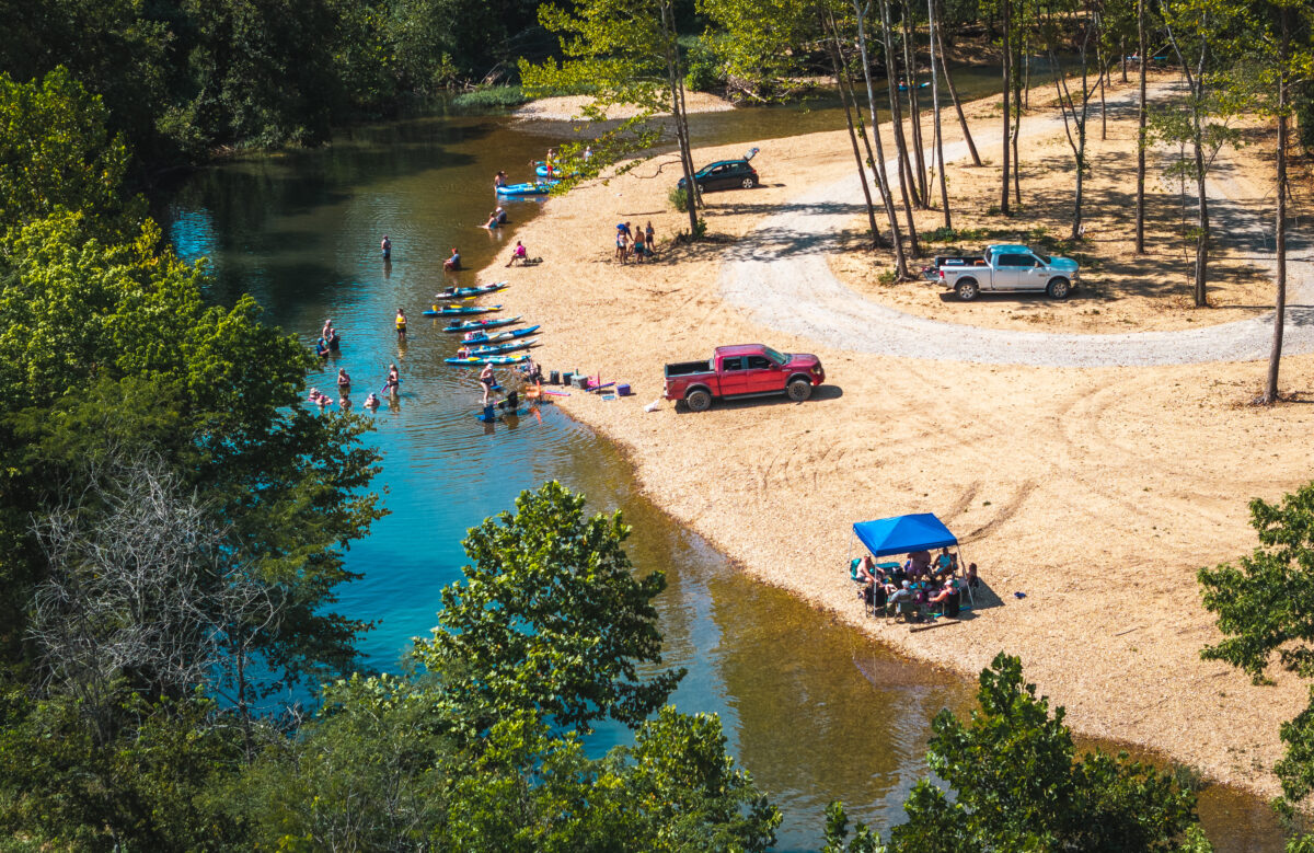 Aerial view of boaters and vehicles on the shore.