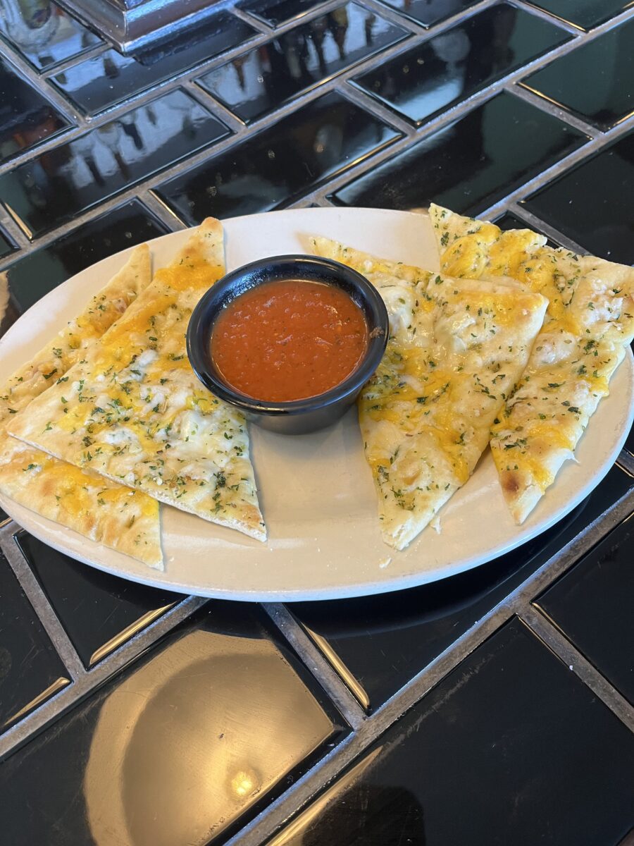 A tortilla dish with a bowl of dip in the middle of the plate.