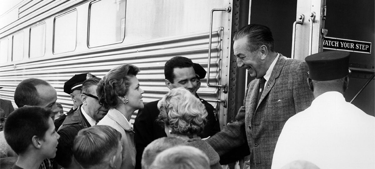 The black and white images show a group of people greet one of the most famous people from Missouri, Walt Disney, while he hops off a train in his hometown of Marceline. 