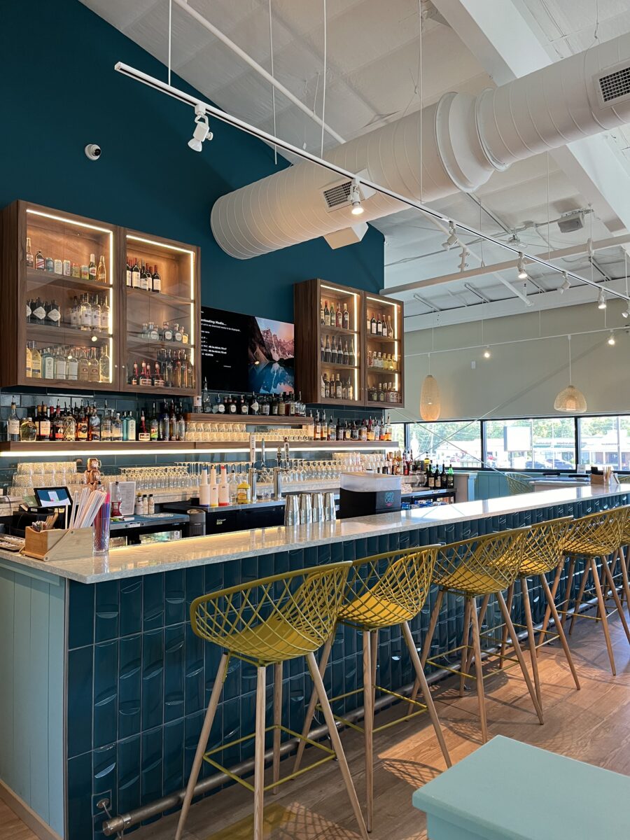 A counter with chairs, lighting and colorful accents.