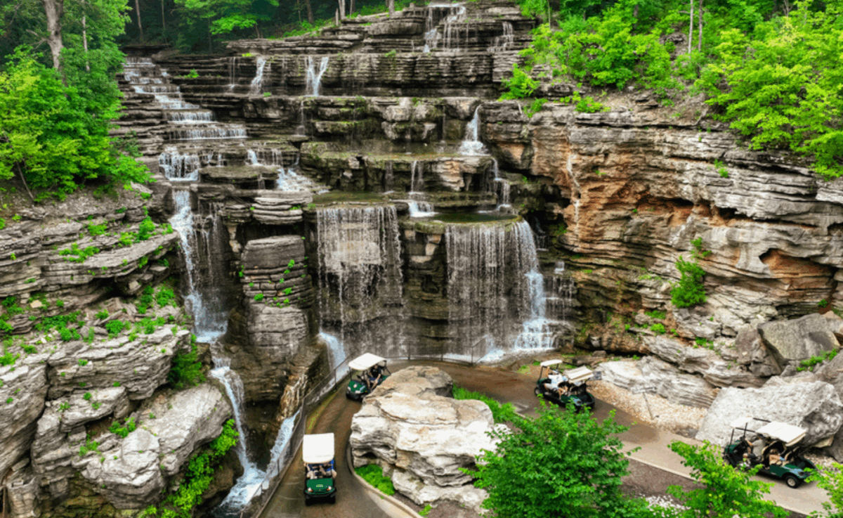 Lost Canyon Cave and Nature Trail golf carts navigate past waterfalls.