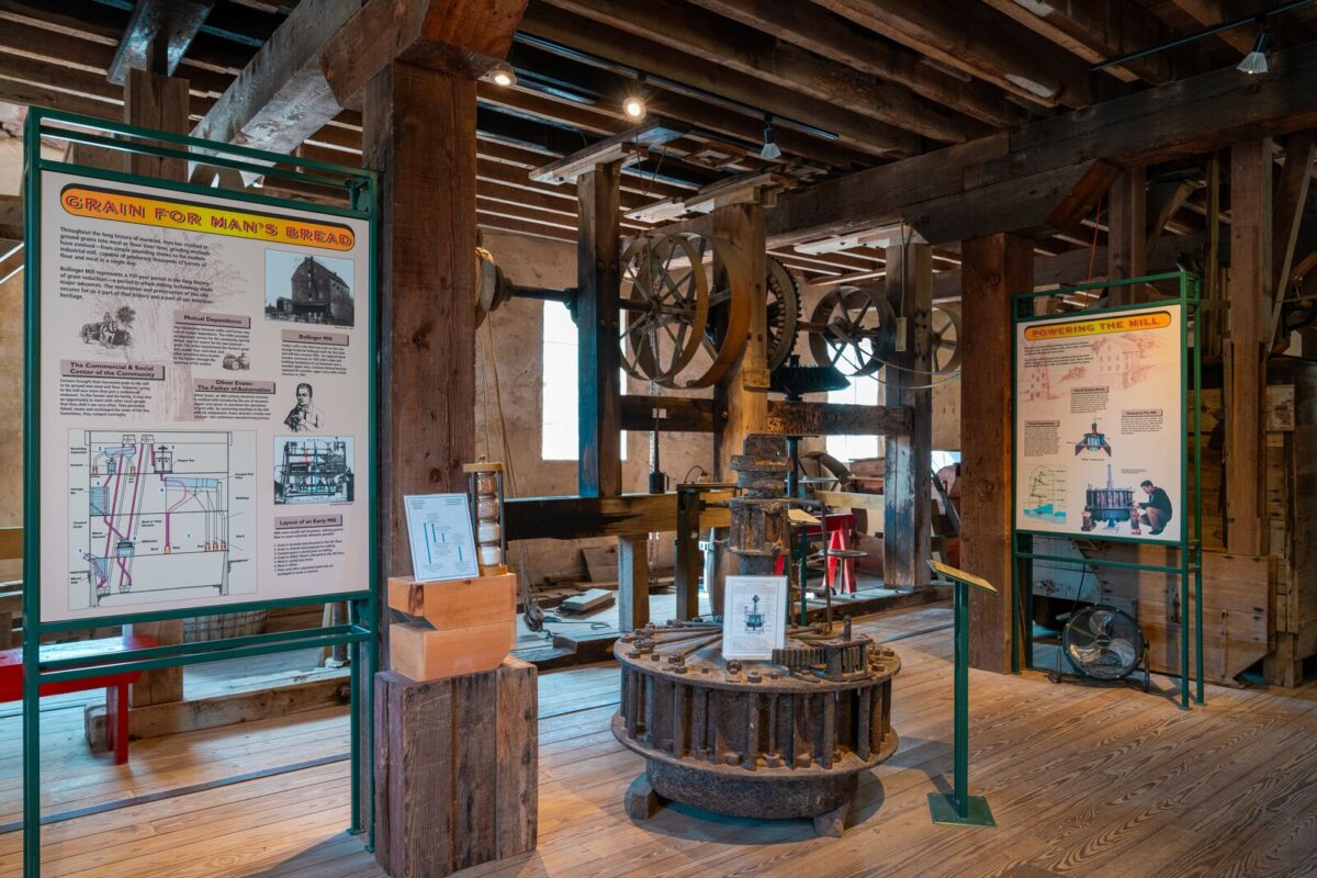 Interpretive panels line the inside of room made with hand hone timbers showcasing historic machinery and information about the use of the mill.