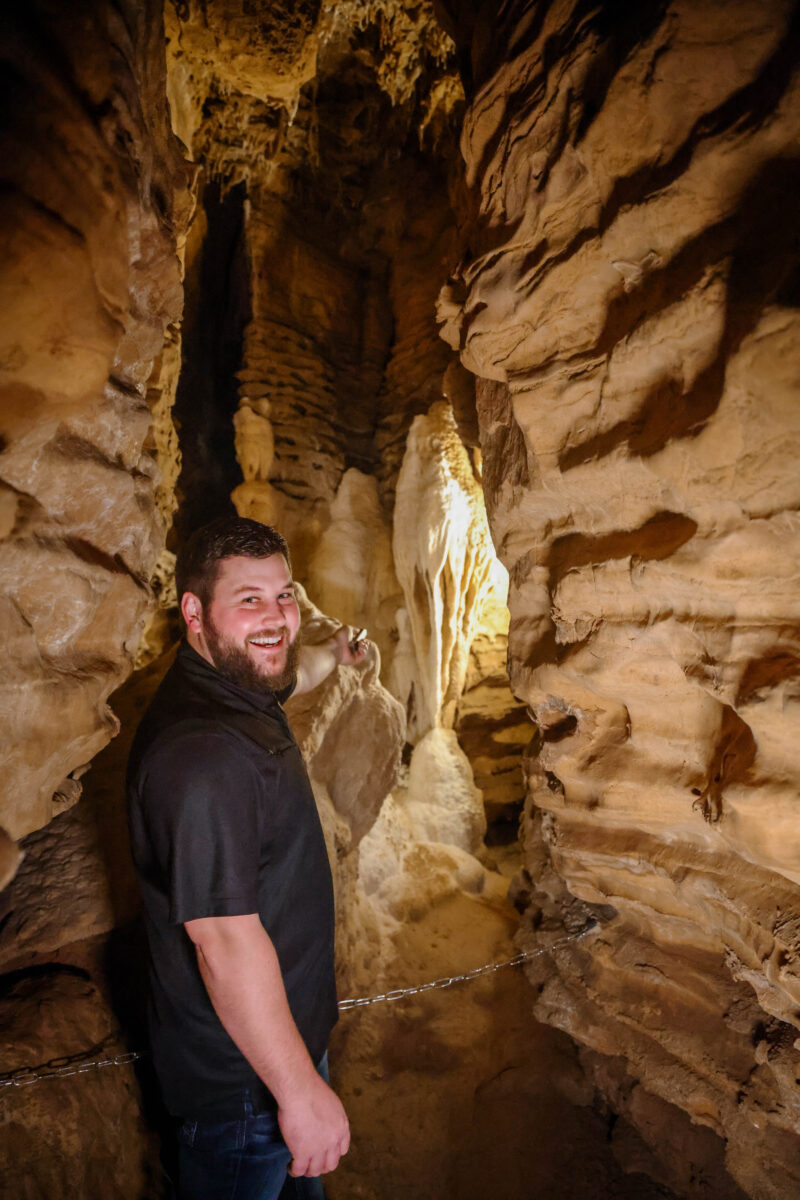A person poses inside a cave.